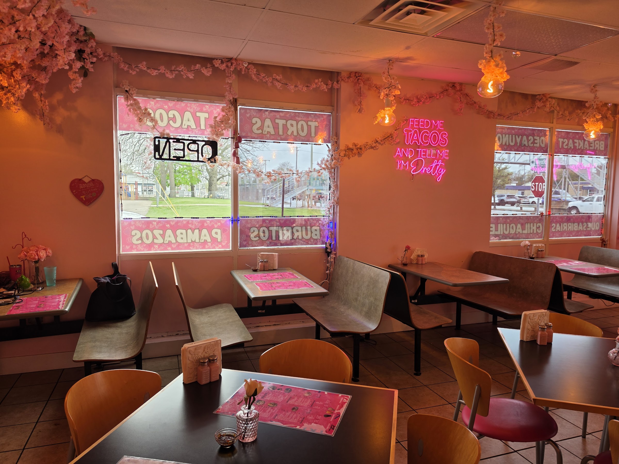 The pink dining room glowing under a 'Feed me tacos and tell me I'm pretty' neon sign